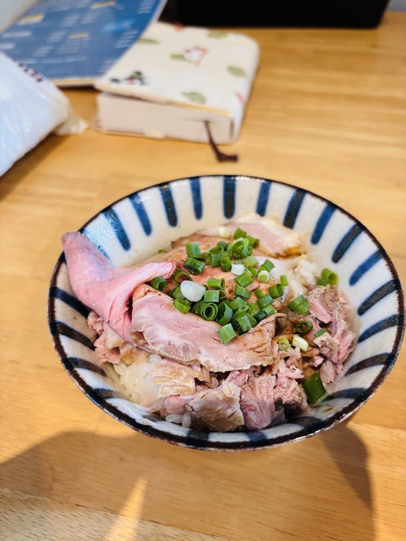 ねぎをのせた小さな豚肉の丼
