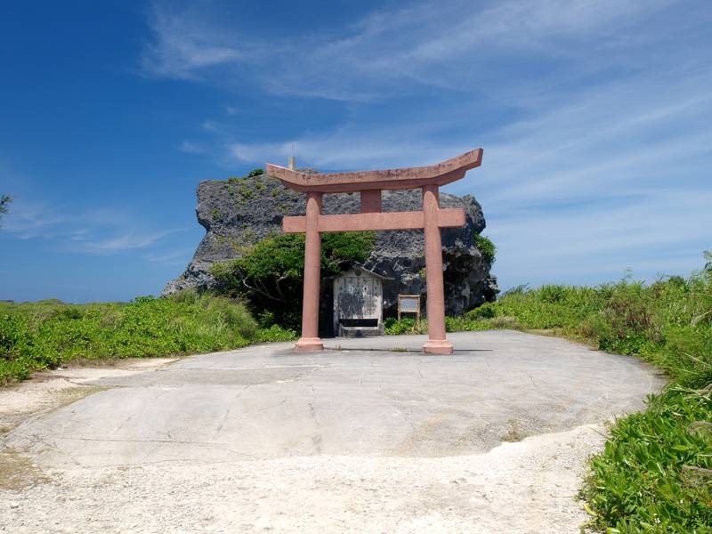 下地島の草原に立つ大きな岩・帯岩と、手前の赤い鳥居